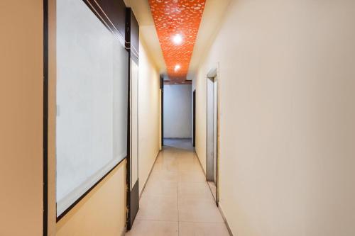 a corridor of a hallway with an orange ceiling at Hotel O Crystal in Ahmedabad