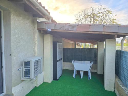 eine Terrasse mit grünem Bodenbelag und Klimaanlage in der Unterkunft La maisonnette de Pizancon in Chatuzange-le-Goubet
