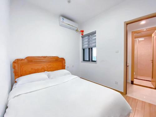 a white bedroom with a bed and a window at Nearby Time in Beihai
