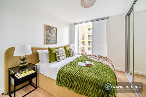 a bedroom with a bed with a green blanket at BRAND NEW! Modern & Spacious Serviced Apartments With FREE Parking & Gym by Rapid Returns - Professional Host in Walton-on-Thames