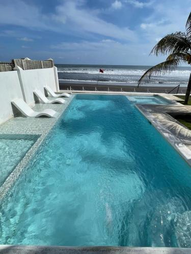 ein Swimmingpool mit dem Meer im Hintergrund in der Unterkunft hotel nativo san blas in Playa San Blas