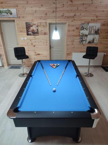 a pool table in a room with two chairs at Durbuy Chalet 9p jacuzzi billard jeux in Durbuy