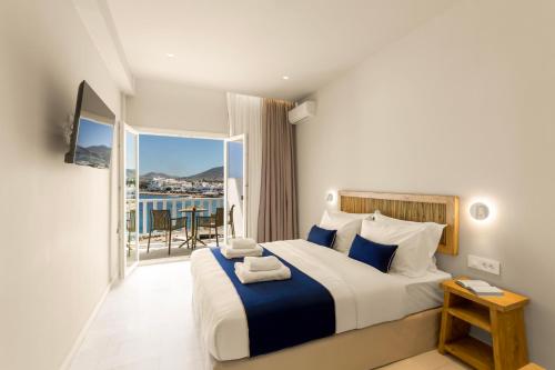 a hotel room with a bed and a balcony at Pandrossos Hotel in Parikia