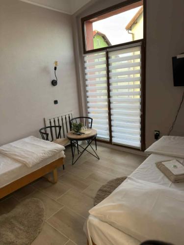a room with two beds and a table and chairs at Hotel Gryf in Gryfice