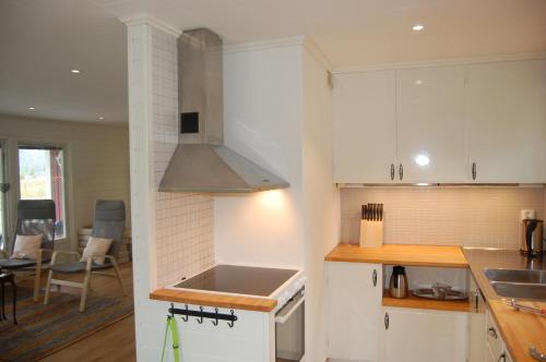 a kitchen with white cabinets and a stove top oven at Holiday Home Sjöhagen in Noby
