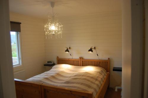 a bedroom with a bed with a chandelier at Holiday Home Sjöhagen in Noby