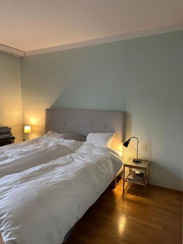 a bedroom with a large white bed and a table at 2 room apartment in Pasila in Helsinki