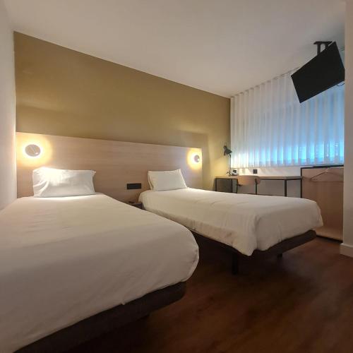 a hotel room with two beds and a window at Hotel Campanile Setubal in Setúbal