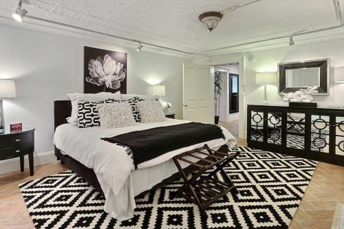 ein Schlafzimmer mit einem großen Bett und einem schwarzen und weißen Teppich in der Unterkunft Under The Red Door On Monterey in Savannah