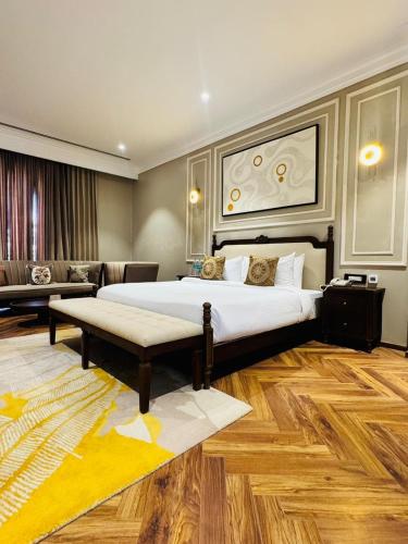 a hotel room with a large bed and a couch at The saffron anandamvillas in Kurukshetra