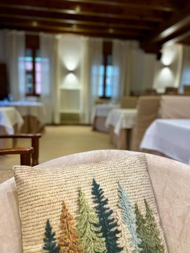 a blanket with trees on it sitting on a couch at Hostal La Placeta in Camprodon