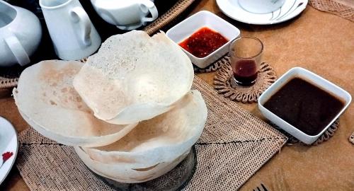 een tafel met een bord brood en twee kommen saus bij Coco Heritance in Tangalle