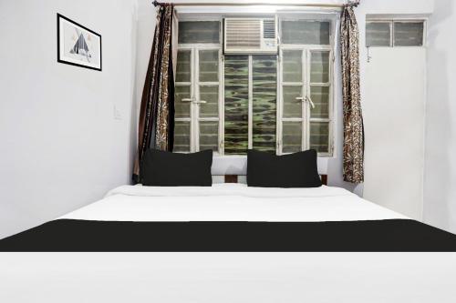 una camera da letto con un letto bianco e una finestra di Hotel O Gol Bagicha Near Railway Station a Gaya