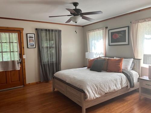 ein Schlafzimmer mit einem Bett mit Deckenventilator in der Unterkunft The coziest Cedar cottage in Fayetteville
