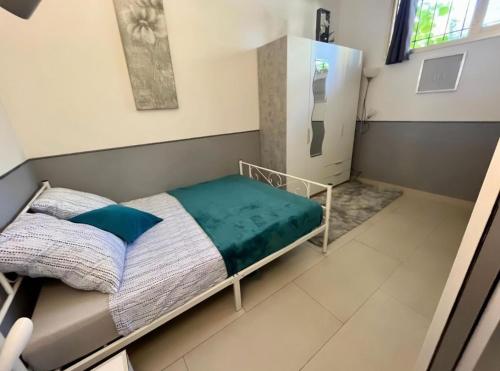 a bedroom with a bed with a green blanket at Le repaire d'Antibes atypique proche parc et mer in Juan-les-Pins