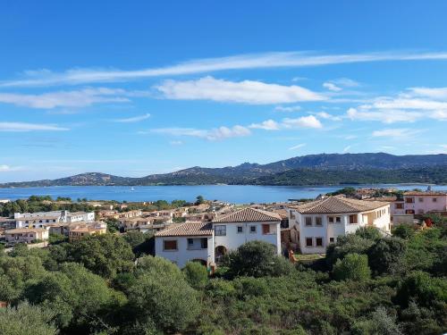een stad op een heuvel met een meer op de achtergrond bij Atemberaubendes Familien Penthouse Mit Meerblick in Cannigione
