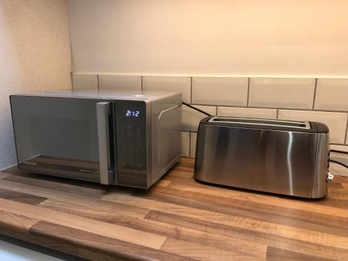 a microwave and a toaster oven on a counter at The Pathfinder's Retreat - 1 bedroom house for 2-3 guests