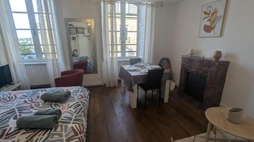 a living room with a bed and a table and a dining room at Appartement Hyper Centre, 2ème étage in Fougères