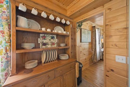 une cuisine avec des placards en bois et des assiettes sur des étagères dans l'établissement Broadstone Cottage, à Banner Elk