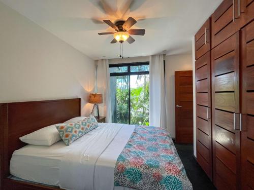 a bedroom with a bed with a ceiling fan and a window at Casa Cielo Luxury Jungle Retreat, Manuel Antonio in Quepos