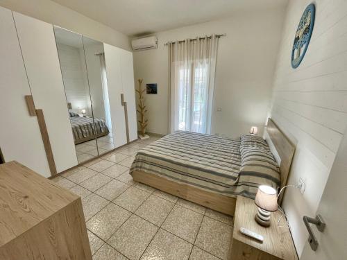 een slaapkamer met een bed en een grote spiegel bij Appartamenti Marisol in Marina di Campo