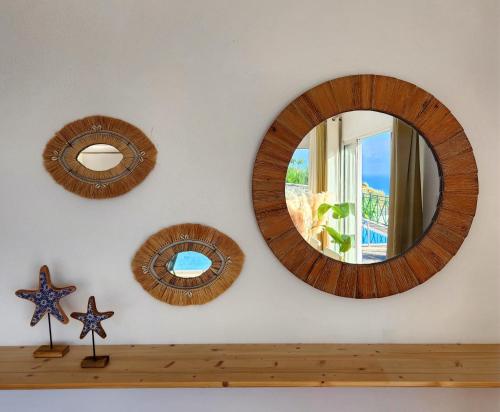 a room with three mirrors on a wall with a shelf at Villa Ocean Wave Calheta - Heated Pool & Stunning Ocean View in Calheta