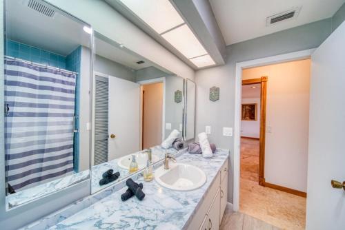 une salle de bain avec un lavabo et un grand miroir dans l'établissement Coral Key Escape w Waterfront Heated Pool-Spa-Direct Gulf Access, à Cape Coral