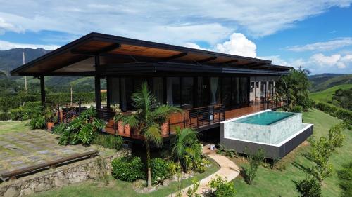 a house with a swimming pool on a hill at Villa Mantiqueira SFX - Cabanas in São Francisco Xavier