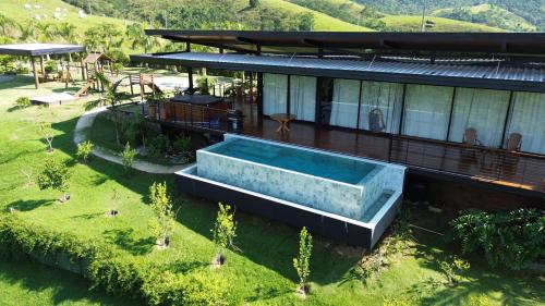 an aerial view of a house with a swimming pool at Villa Mantiqueira SFX - Cabanas in São Francisco Xavier