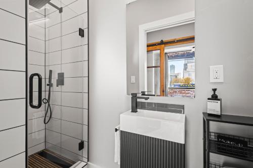 a white bathroom with a sink and a window at Downtown Denver Suite - Skyline Views in Denver
