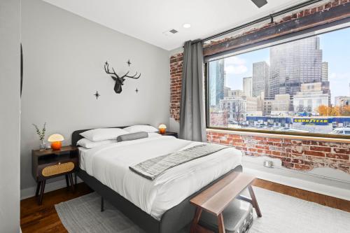 a bedroom with a bed and a large window at Downtown Denver Suite - Skyline Views in Denver