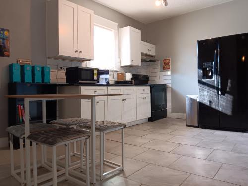 a kitchen with white cabinets and a black refrigerator at Hostel Tampa near downtown, 15 minutes to airport, self check-in, NO BREAKFAST in Tampa