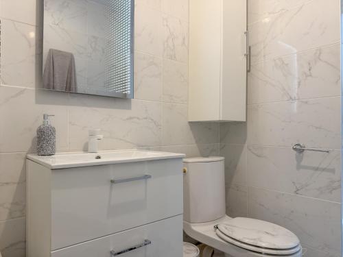 ein weißes Badezimmer mit Toilette und Waschbecken in der Unterkunft White dream in Gréolières les Neiges