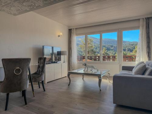 ein Wohnzimmer mit einer Couch und einem Glastisch in der Unterkunft White dream in Gréolières les Neiges