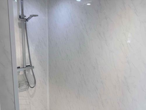 a bathroom with a shower with white tile at Twelfth Man Accommodation part of The Twelfth Man Public House in Liverpool