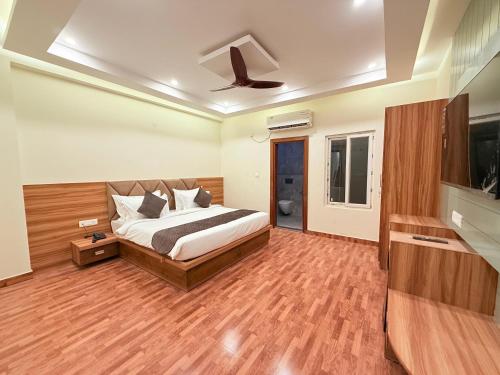 大诺伊达The Prominence Hotel Greater Noida的一间卧室，里面有一张床和一台平板电视