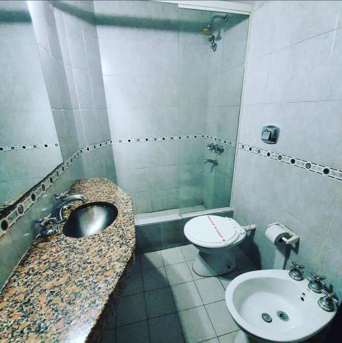a bathroom with a sink and a toilet at Hotel Paris in General San Martín