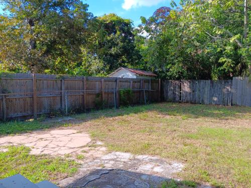 a backyard with a wooden fence and a yard at Hostel Tampa near downtown, 15 minutes to airport, self check-in, NO BREAKFAST in Tampa