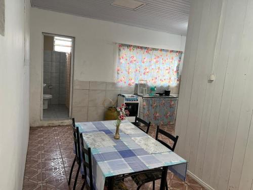 Zimmer mit einem Tisch mit Stühlen und einer Küche in der Unterkunft Casa perto da Expointer in Esteio