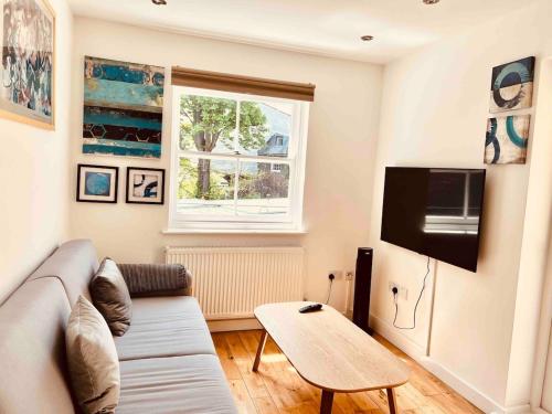 a living room with a couch and a table at Hidden Gem in Kensington in Finchley