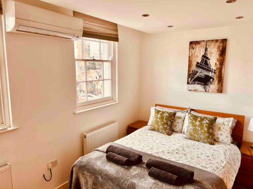 a bedroom with a bed and two windows at Hidden Gem in Kensington in Finchley