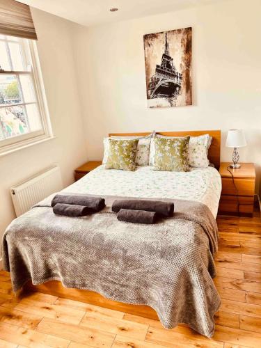 a bedroom with a large bed with two towels on it at Hidden Gem in Kensington in Finchley