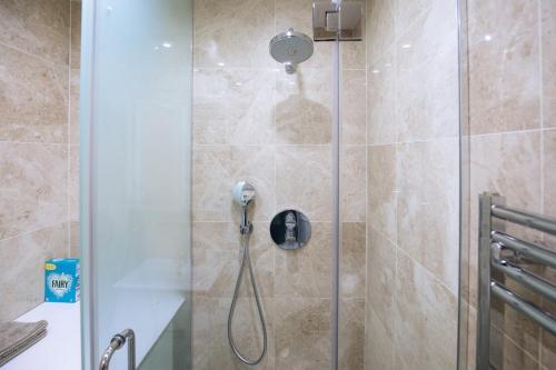 a shower with a shower head in a bathroom at Hidden Gem in Kensington in Finchley