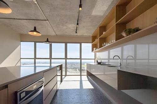 een keuken met witte werkbladen en een groot raam bij Hype 017 in Princesa dʼOeste