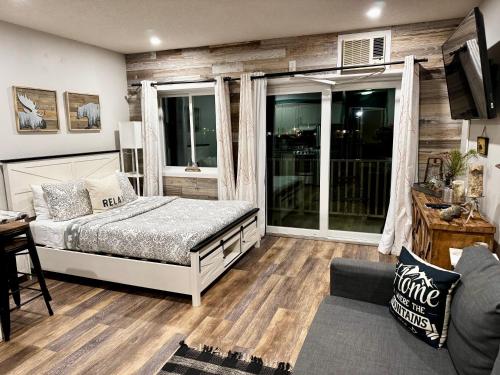 ein Schlafzimmer mit einem Bett, einem Fernseher und einer Couch in der Unterkunft B103 Stylish Loon Mountain Studio Condo with Pool and Hot Tub in Lincoln