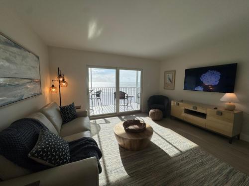 un soggiorno con un divano e un tavolo di Irresistible Beach Life, Spectacular Sunsets - FMB - Condo Sunset Vista - Roelens a Fort Myers Beach