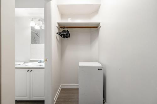 a white bathroom with a sink and a refrigerator at Grantview Inn in Surrey