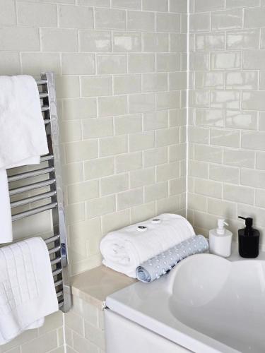 a white bathroom with a sink and towels at Red Bull in Stockport