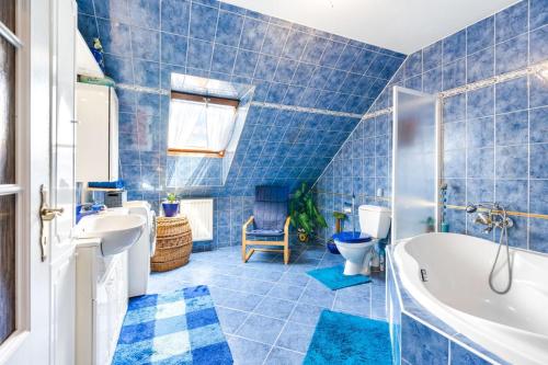 a blue tiled bathroom with a tub and a sink at Rezidence Jih in Hlavňovice