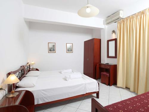 a bedroom with a large white bed and a table at Villa Anna in Hanioti